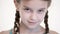 Close-up open look of a Caucasian girl with a pigtails opening and closing her eyes. Angry and blind in the camera