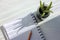 Close up of open paper notepad on a spiral with white pages, a pencil, and aloe vera plant in a glass jar on a wooden white window