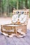 Close up of an open picnic basket over wooden table in the park.