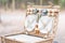 Close up of an open picnic basket over wooden table in the park.