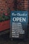 Close up of open sign outside St Anthony of Padua Church in Rye, UK