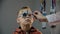 Close up. The ophthalmologist examines the patient teen boy eye and puts on a device for selecting lenses for glasses