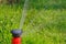 Close-up of orange automatic sprinkler while grass irrigation