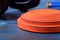 Close-up of orange flying target plate on blue wooden table