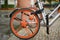 Close-up of the orange rear wheel of a bicycle with modern spokes on a rainy day in Berlin, Germany