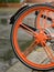 Close-up of the orange rear wheel of a bicycle with modern spokes on a rainy day in Berlin, Germany