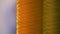 Close-up of orange and yellow thread spools.