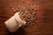 Close-up of Organic chana or chickpea Cicer arietinum or whole white Bengal gram spilled out from a laying jute bag over wooden