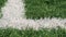 Close up of the out of bounds line on a turf football field.