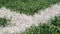 Close up of the out of bounds line on a turf football field.