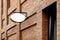 Close-up outdoor oval advertising sign on a brick wall