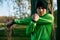 Close up outdoor shot of athlete healthy young man stretching in the park, looking directly to the camera. Sportive male warming