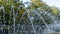 Close-up outdoor view of a public fountain with many small water jets. Public park background.