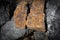 Close up outdoor view of stone on the ground. Piece of orange rocky stone. Beautiful texture