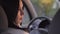 Close up over the shoulder shot of young beautiful woman sitting in drivers seat of car