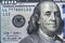 Close up overhead view of Benjamin Franklin face on 100 US dollar bill. US one hundred dollar bill closeup. Heap of one hundred