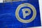 Close up of P sign Parking guidepost on blue grungy wooden.