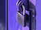 Close-up padlock on the gate of a metal fence made of modern siding, at night, security concept