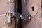 Close up of padlock and old hasp on an old wooden door.