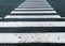 close up of painted white lines on asphalt on a pedestrian crossing zebra cross walk