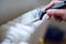 Close up of painter arm painting a heating radiator with paint roller. Professional Workman Hand holding Dirty Paintbrush.