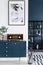 Close-up of a painting, blue cabinet, retro radio and glass vase