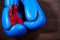 Close-up of a pair of boxing blue and red gloves hanging on the wooden wall.