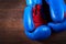 Close-up of a pair of boxing blue and red gloves hanging on the wooden wall.