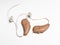 Close up of a pair of tiny modern hearing aids on white background