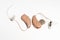 Close up of a pair of tiny modern hearing aids on white background