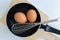 Close up pan with egg and stainless steel egg whisk and chopping