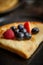 Close up on pancake with fresh fruit topping placed on dark rusty table