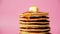 Close-up pancakes with butter and trickling drop honey or maple syrup on pink background. High quality 4k footage