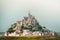 Close up panorama hazy dramatic Mont Saint-Michel, France. Built in the XI-XVI centuries. The main facade of the church built in