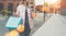 Close-up of paper bags in female hand.Young woman carries shopping bags and drinks coffee.