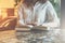 Close-up of paper book, notebook, diary on table in cafe. Businesswoman in white shirt sitting at table and reading book