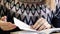 Close-up of paper book, notebook, diary on table in university. Girl leafing through notebook. Girl sits at table in