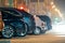 Close up of parked cars on roadside at night with blurred view of traffic lights of moving vehicles on city street