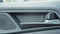 Close-up of a part of a car interior, leather door upholstery, speaker and door handle