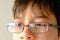 Close-up of part of child`s face, boy 10-12 years old in glasses, stress problems, difficult childhood, victim of domestic