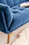 Close-up of a part a couch dressed in luxurious navy blue tapestry in a living room interior. An open book on the sofa. Real photo