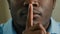 Close up part face man silent mysterious african american 30s male businessman put finger to lips make silence hush