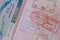 close up part of pages of foreign passport with foreign visas, border stamps, permits to enter countries, concept of traveling