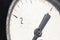 A close-up of a part of the white dial of an old manometer with an arrow at zero. Production stop and malfunction