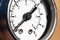A close-up of a part of the white dial of an old manometer with an arrow at zero. Production stop and malfunction