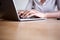 Close up partial woman sitting and typing on laptop computer in home office