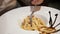 Close-up of pasta in a large plate. Woman`s hand with fork