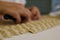 Close up of pasta making process. Woman makes orecchiette, ear shaped pasta, traditional to the Puglia region of Italy.