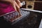 Close-up of a pastry chef`s hand holding a candy bag and squeezing liquid warm chocolate mass into candy molds