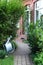 Close up from a paved path with house facade and watering can.